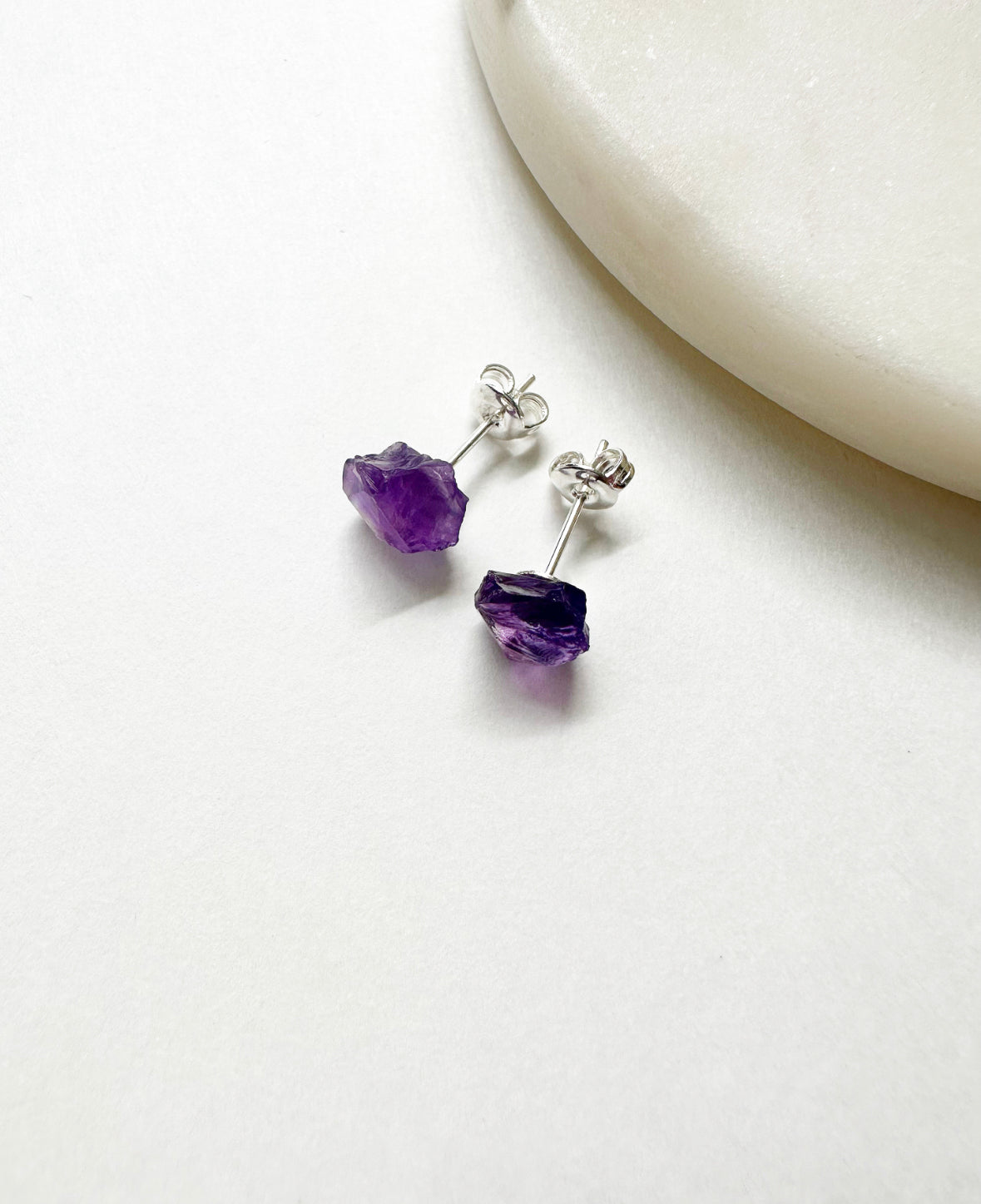 Raw amethyst birthstone stud earrings with sterling silver post.