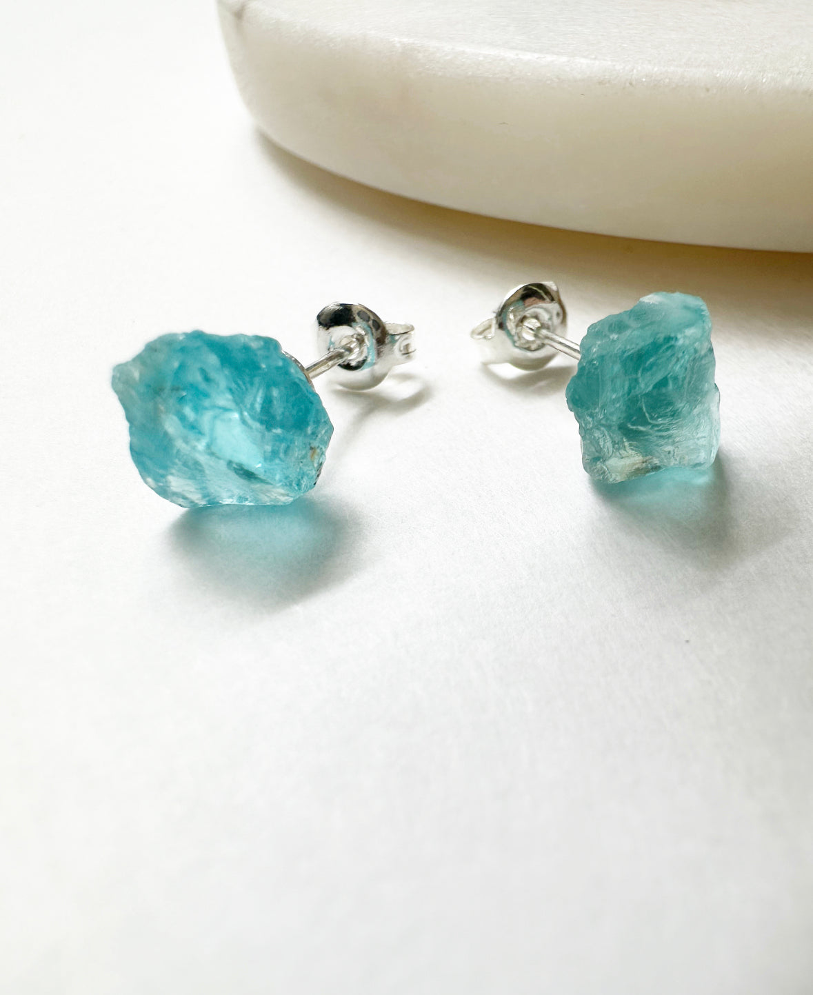 Close-up of raw aquamarine stud earrings.