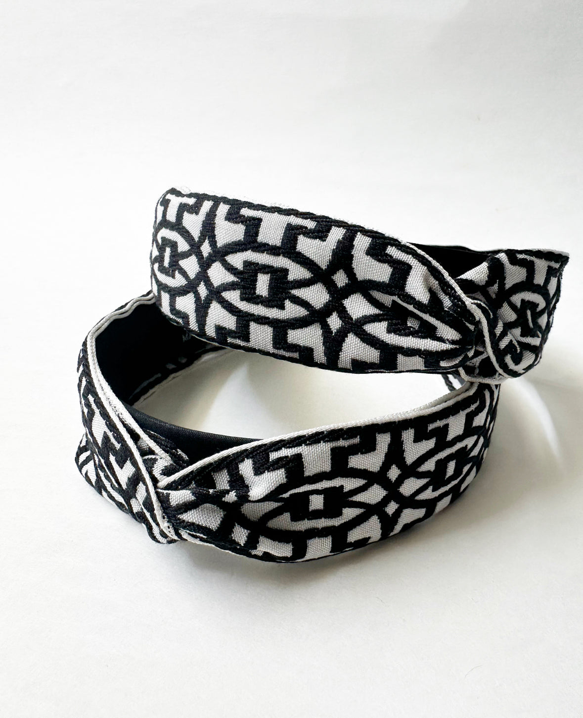 Photo of two Black/White That Girl Headbands stacked on top of each other at different angles. The photo clearly shows Moroccan quatrefoil pattern.