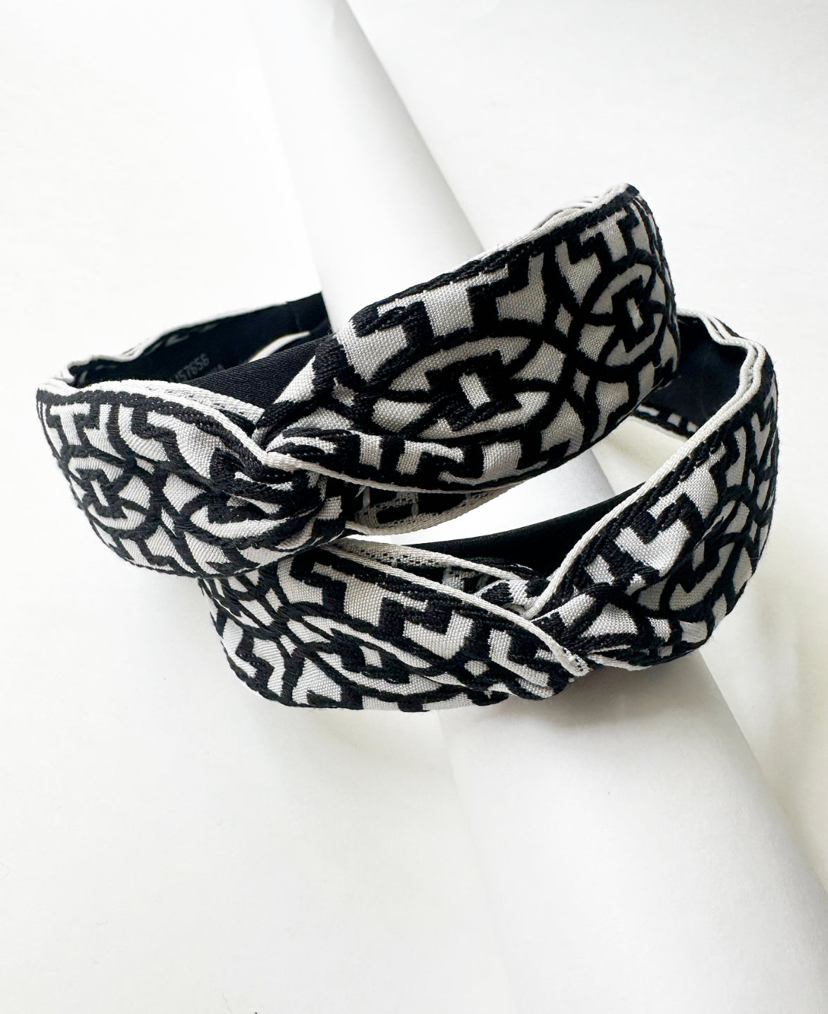 Photo of the front of two Black/White That Girl Headbands stacked on top of each other.