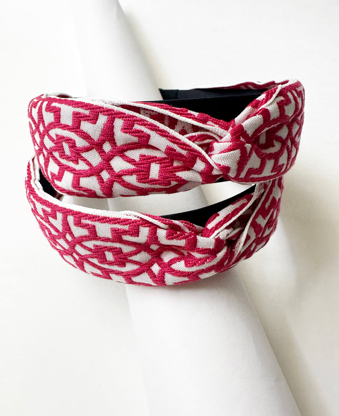 Photo of the front of two Magenta/White That Girl Headbands stacked on top of each other.