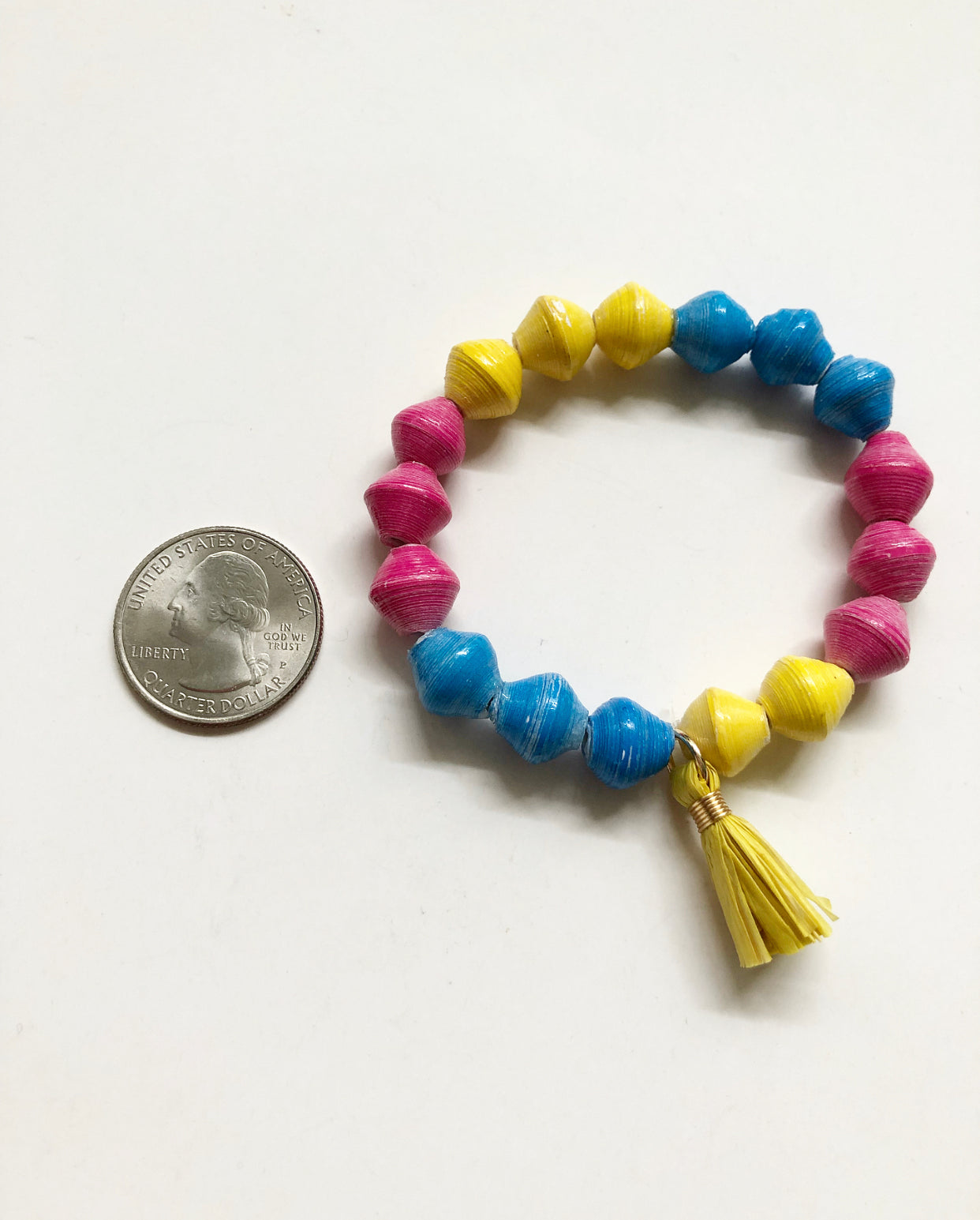 Candy Colored Bracelet next to a quarter for size comparison.