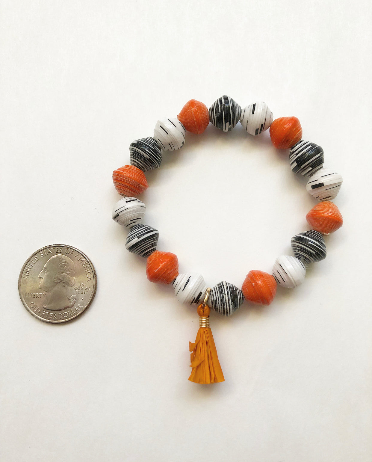 Pumpkin Spice Bracelet next to a quarter for size comparison.