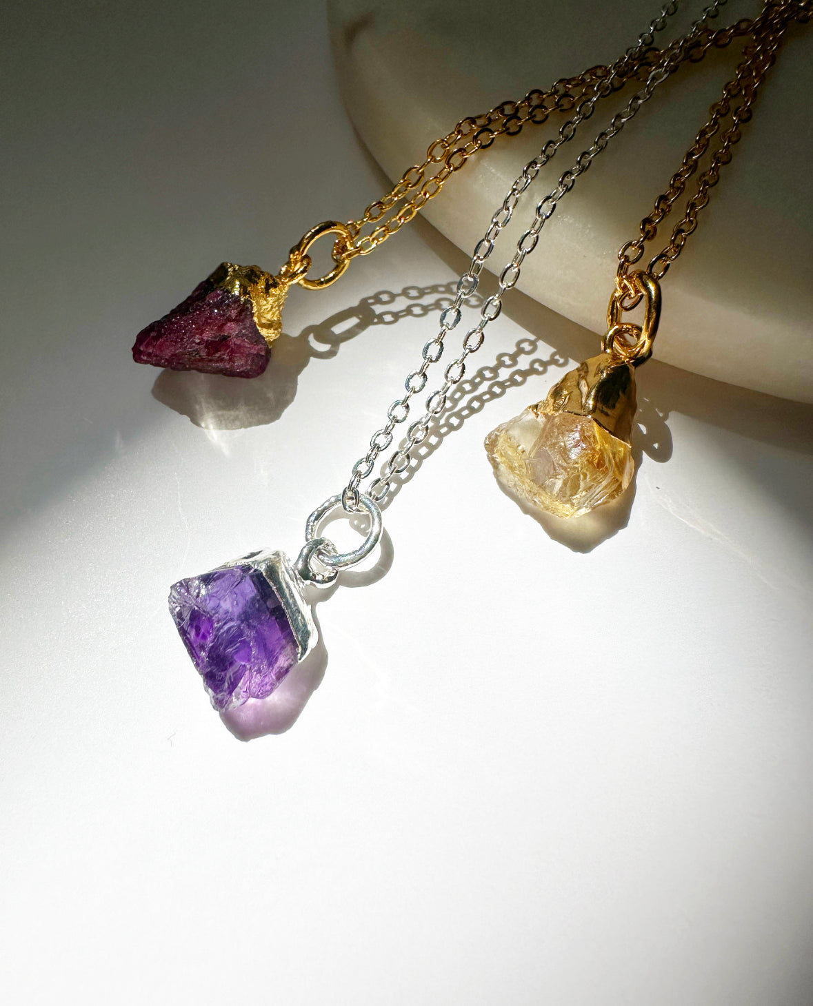 Photo of ruby, amethyst, and citrine necklaces.