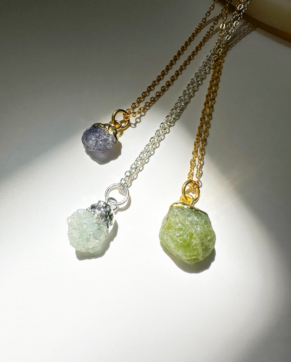 Photo of sapphire, aquamarine, and peridot necklaces.