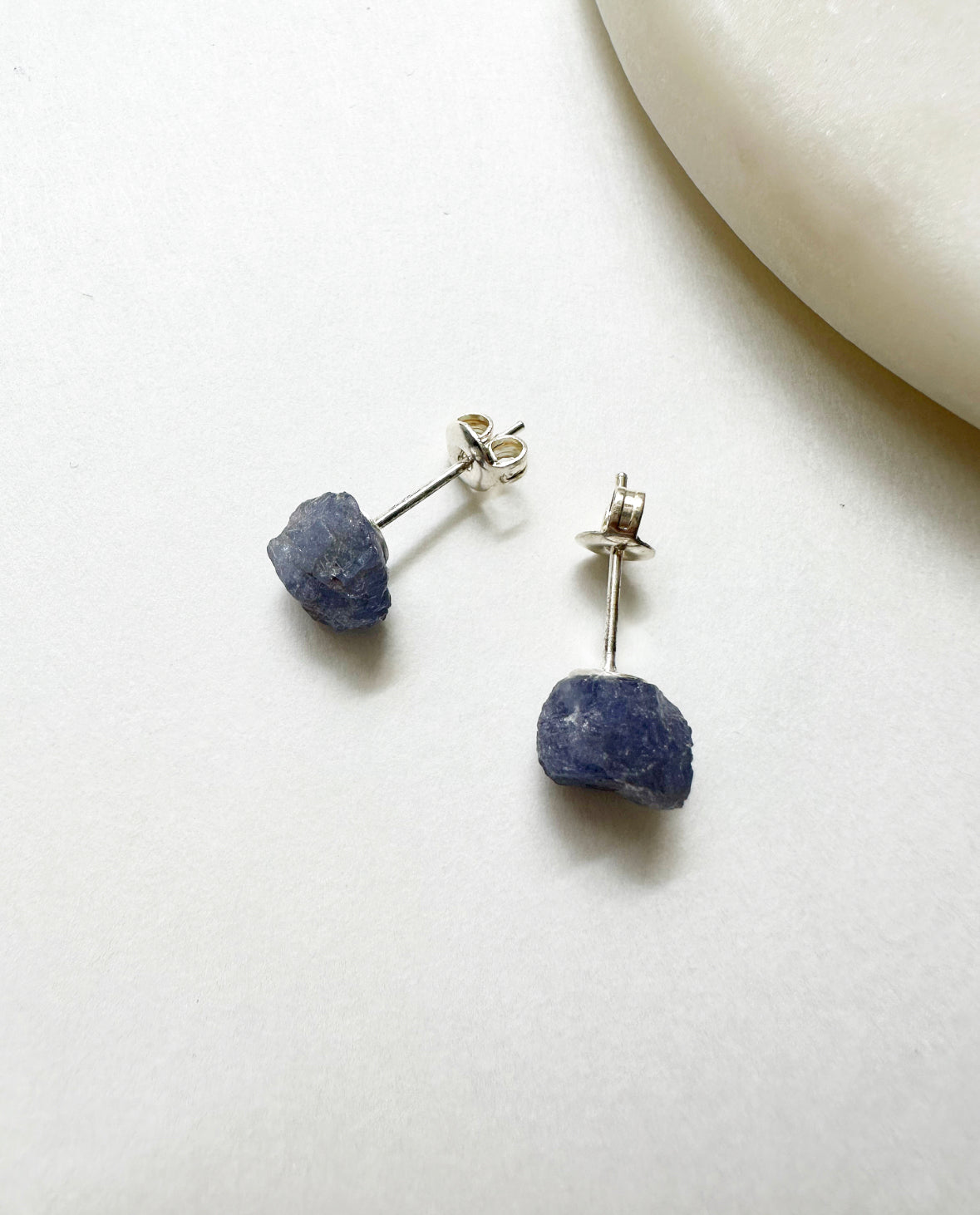 Raw tanzanite birthstone stud earrings with silver post.