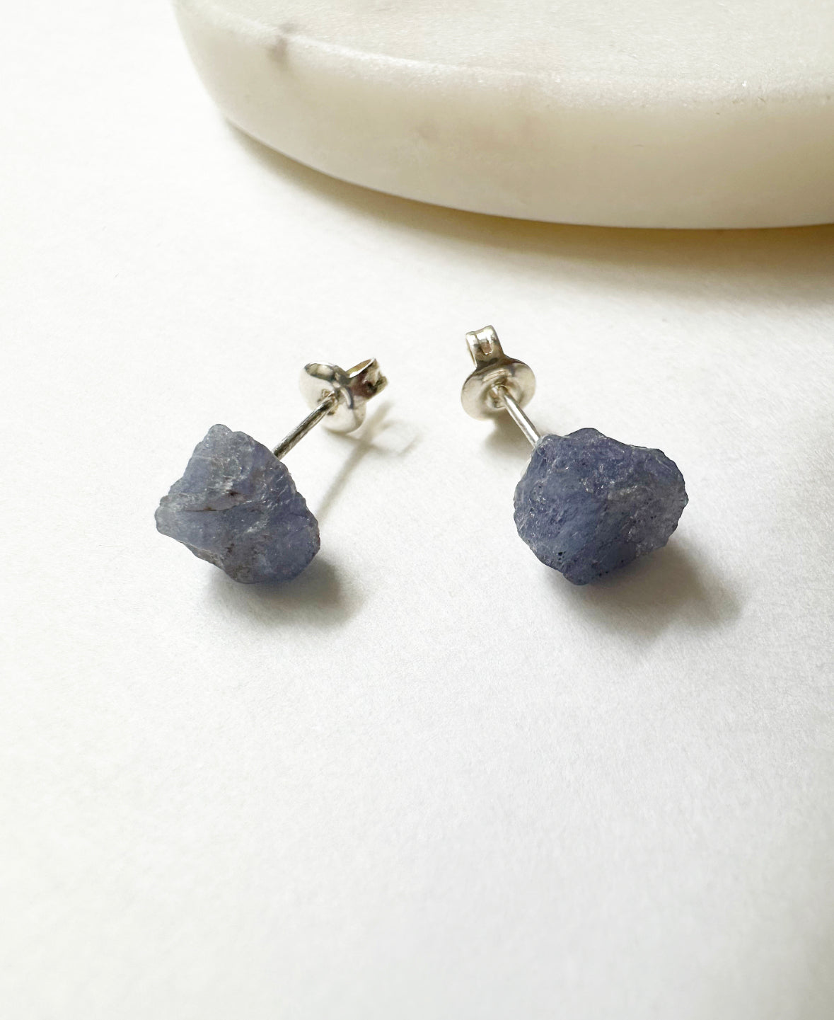 Close-up view of our raw tanzanite birthstone stud earrings.