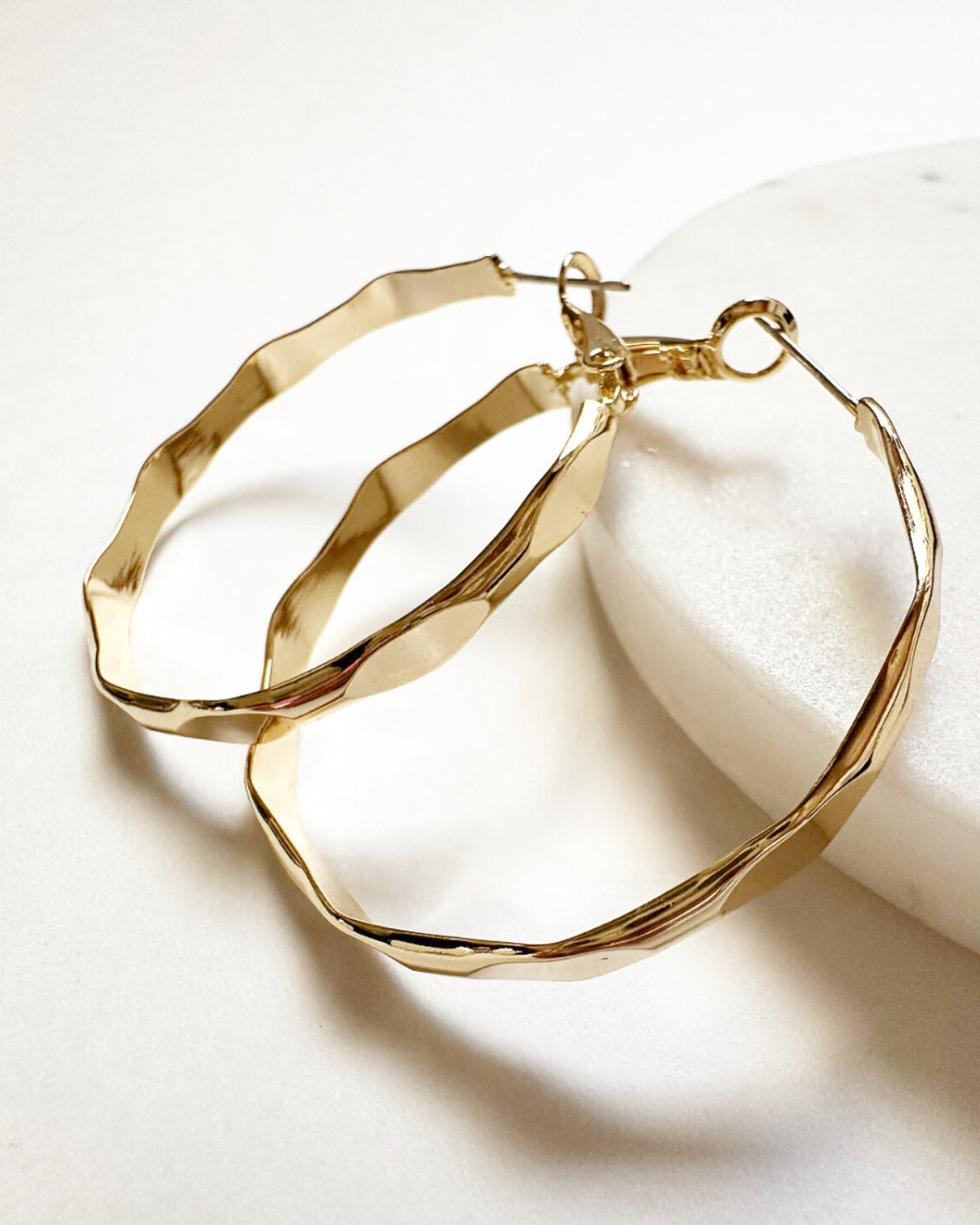 Close-up view of hammered pattern detailing and latch back closure on Vada Hoops.