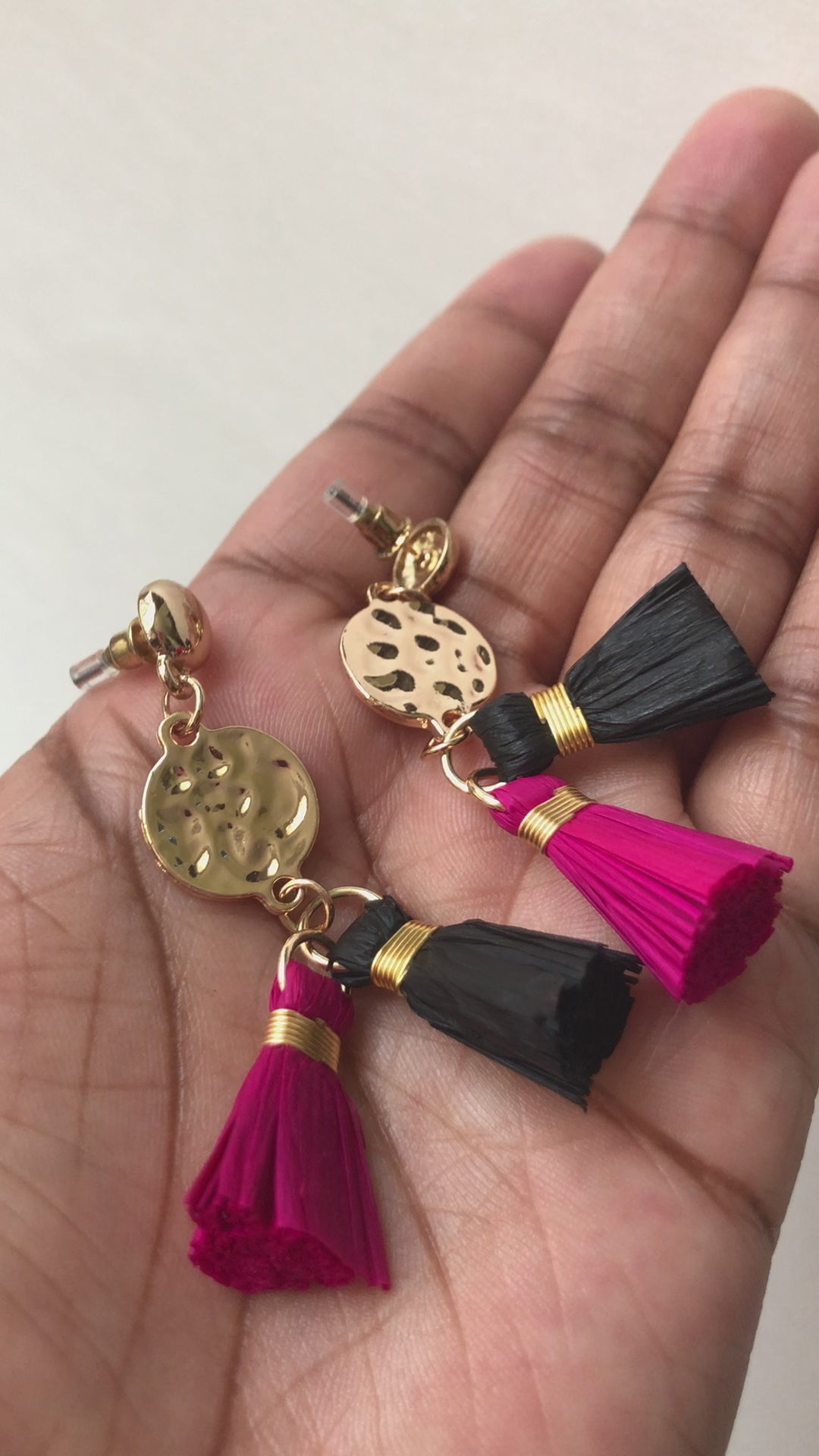 A real-time view of our It Girl Raffia Earrings shown on the palm of model's hand.