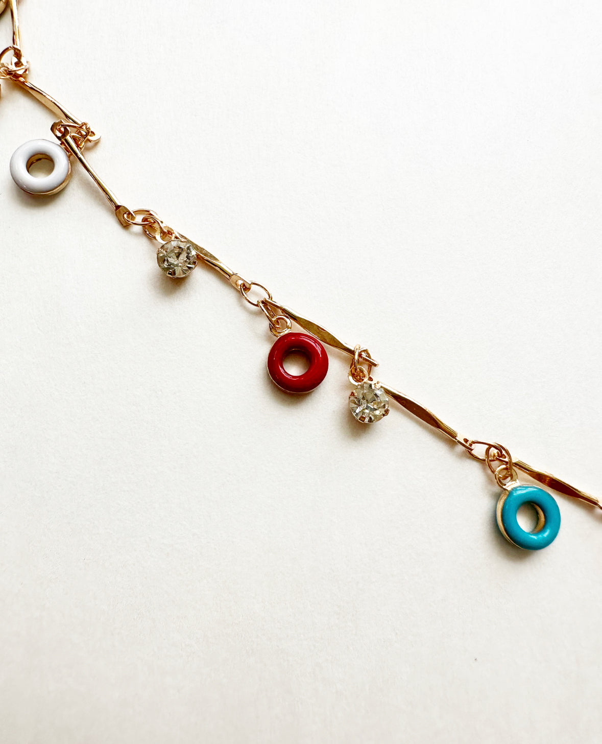 Close-up on chain link, rhinestone, and charm details on Confection Choker Necklace.