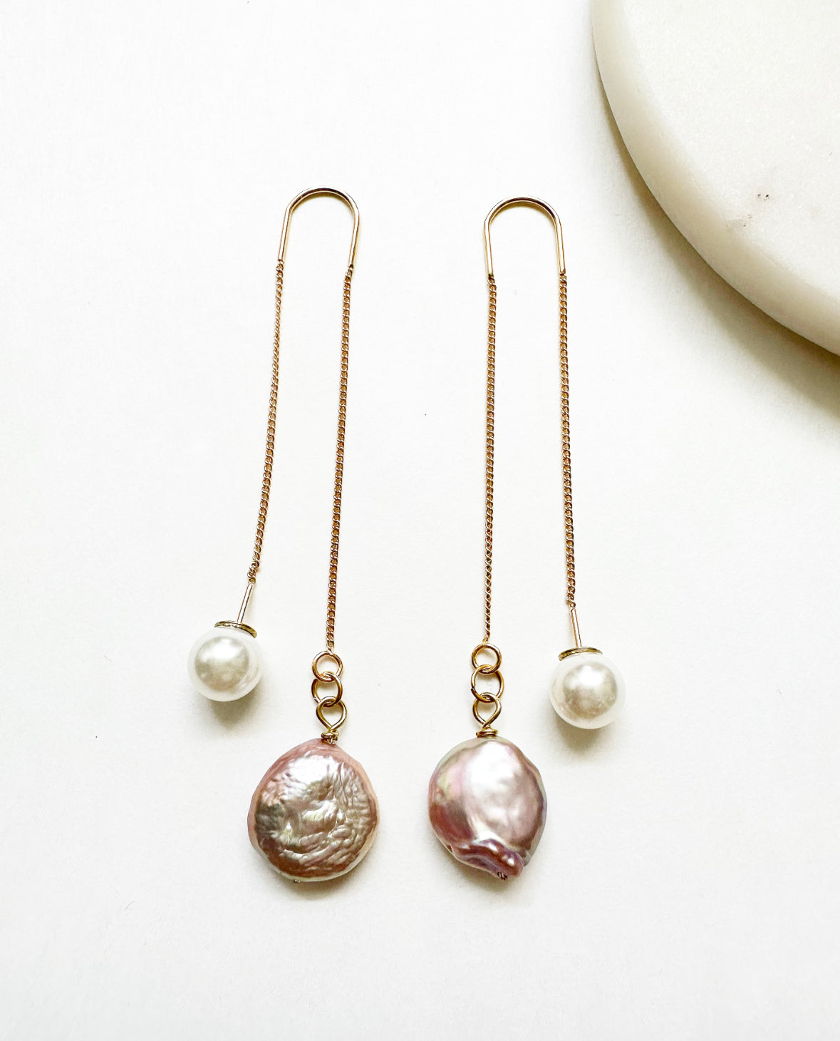 Full view of our Adorn Earrings featuring 18k gold plating with a natural blush freshwater coin pearl and a white faux pearl hypoallergenic stopper.