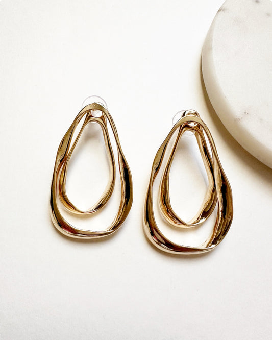 Our gold-toned Amia Earrings featuring double hoops and a detachable smaller single hoop.