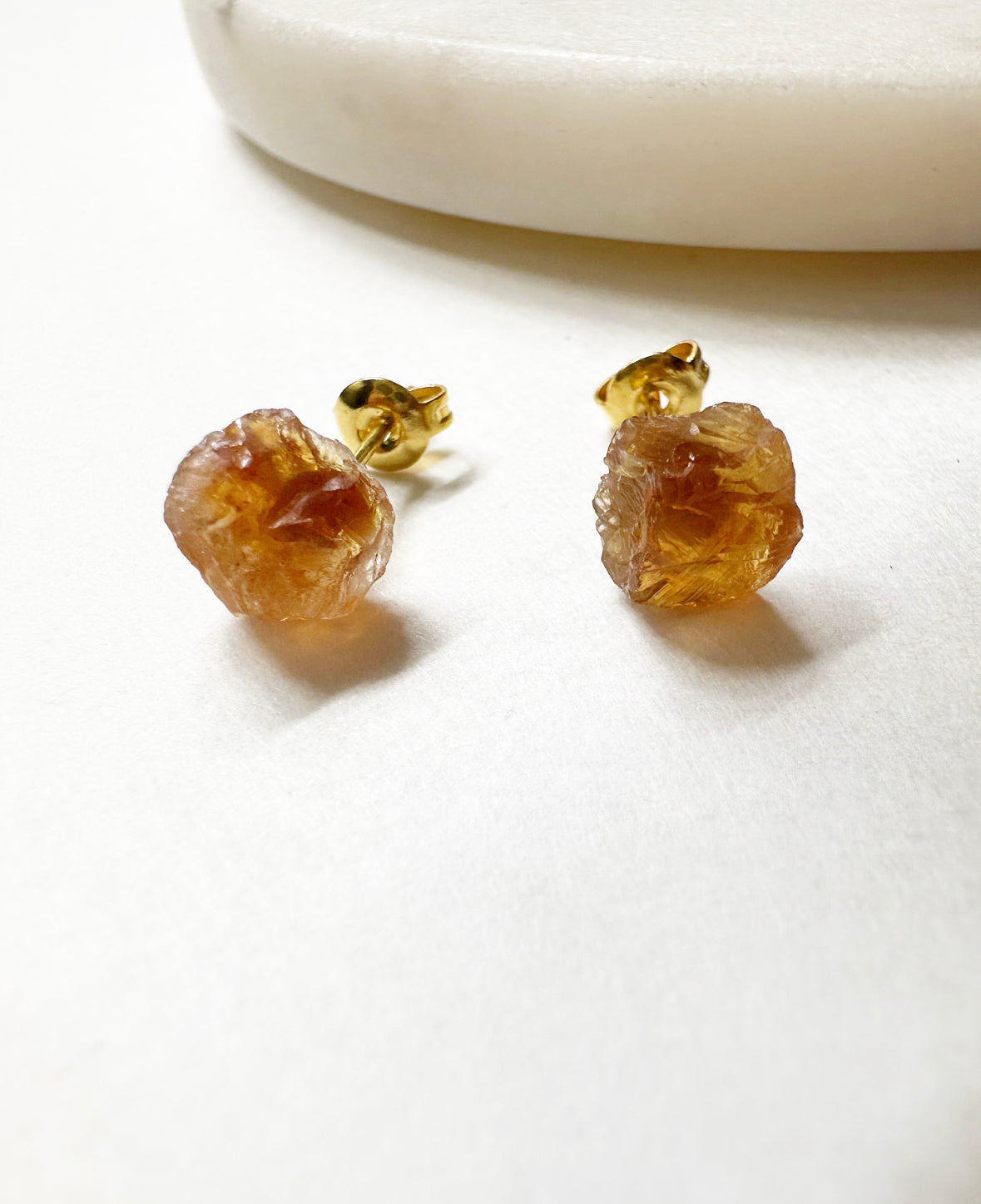 Close-up of raw citrine stud earrings.