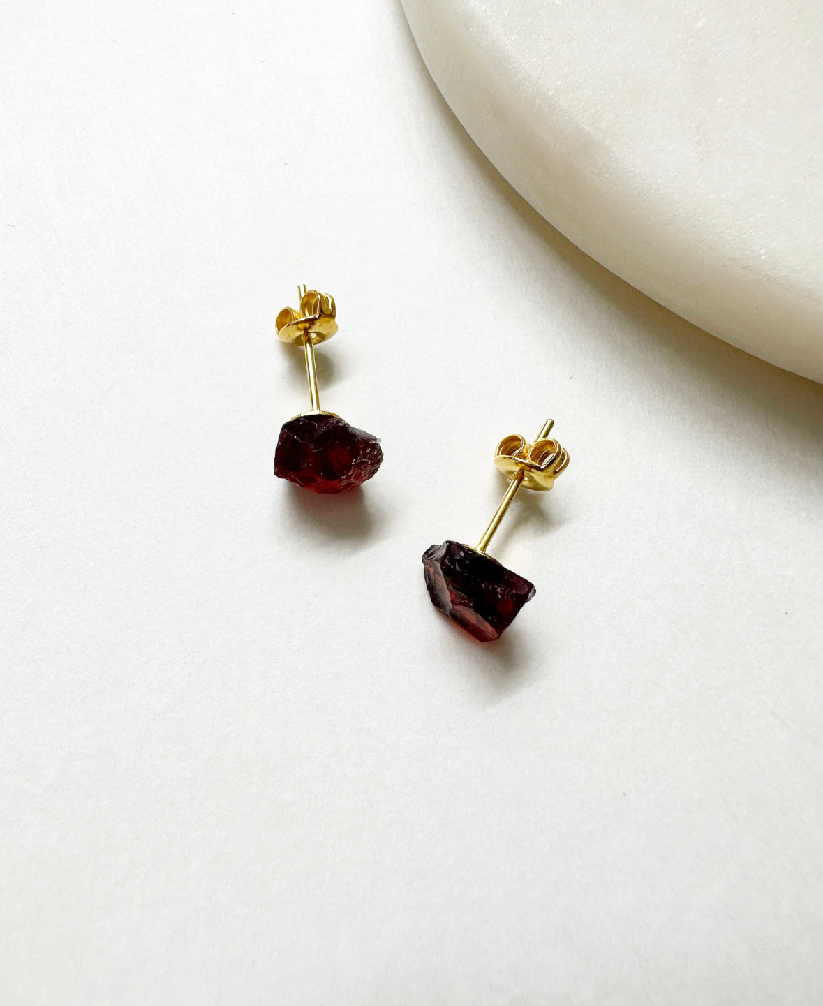 Raw garnet birthstone stud earrings with 14k gold post.