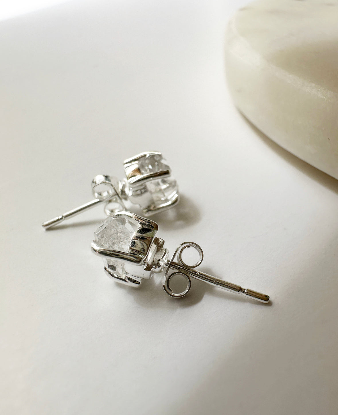 Close-up photo of raw Herkimer Diamond Birthstone Stud Earrings with sterling silver push-back post.