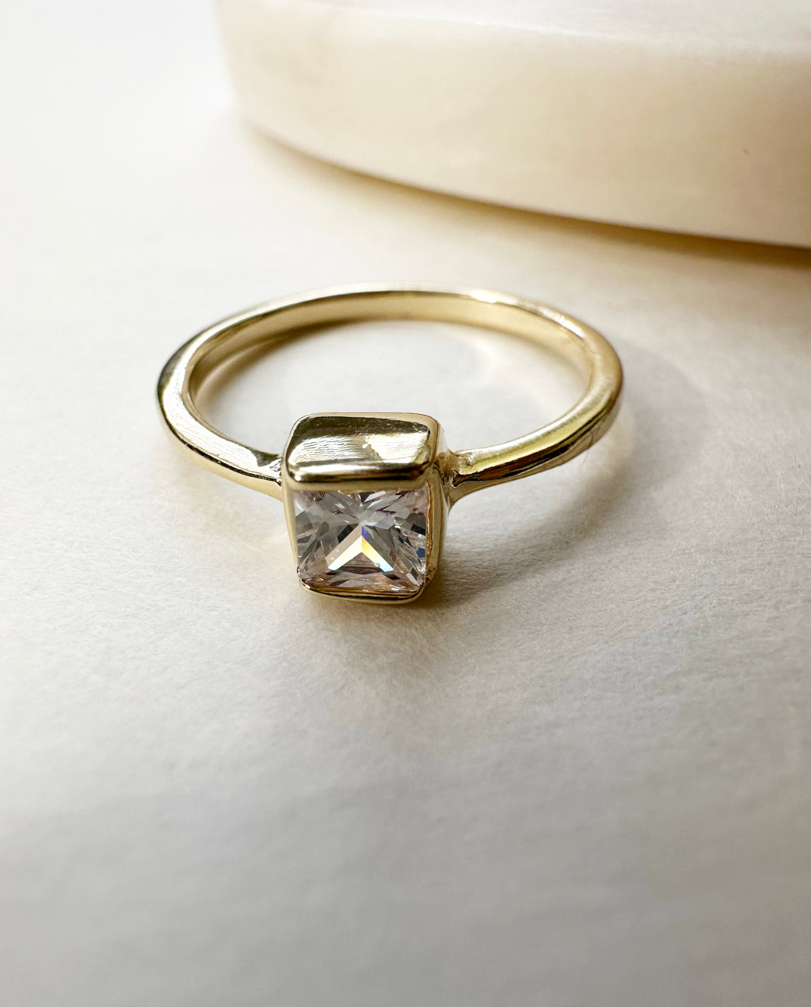 Angel of Mine Ring featuring a square solitaire cubic zirconia stone in an 18k gold-filled bezel setting.