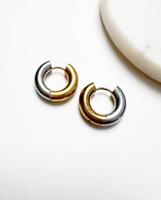 Our Xena Mini Hoops featuring a dual-toned silver and gold-plated finish on stainless steel huggie-style earrings.