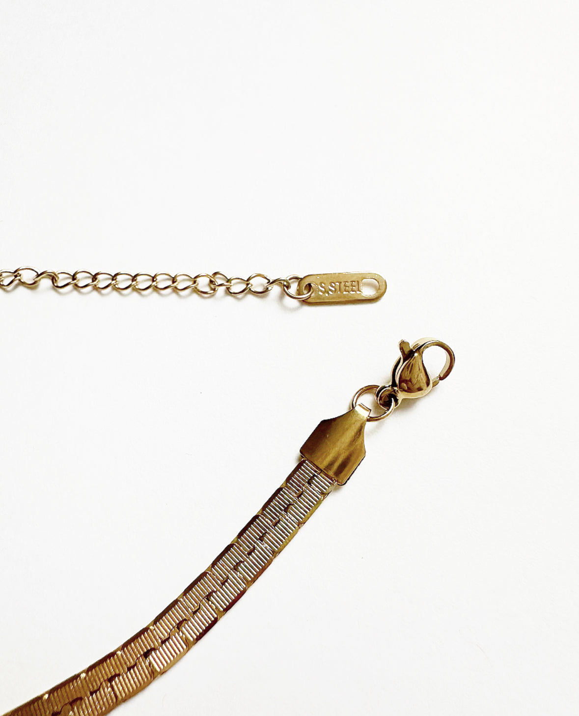 Close-up of Stainless Steel tag on chain extender and lobster clasp on our Billie Chain Necklace.