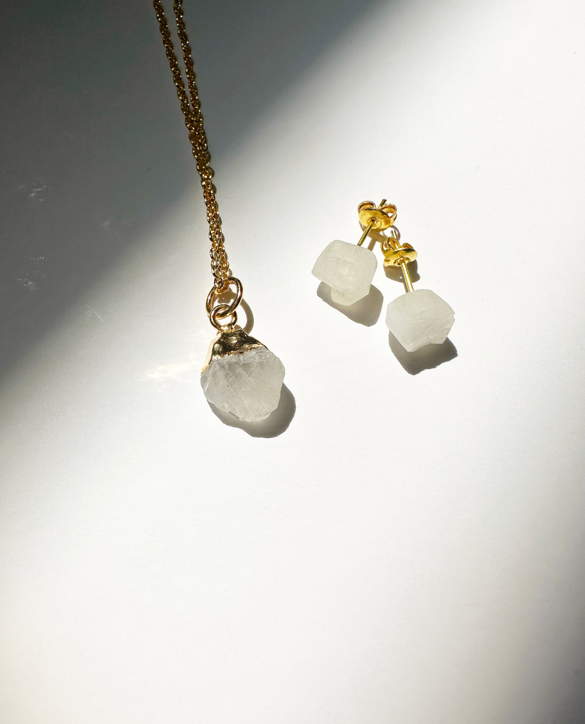 Photo of raw rainbow moonstone birthstone necklace and matching raw rainbow moonstone birthstone stud earrings.