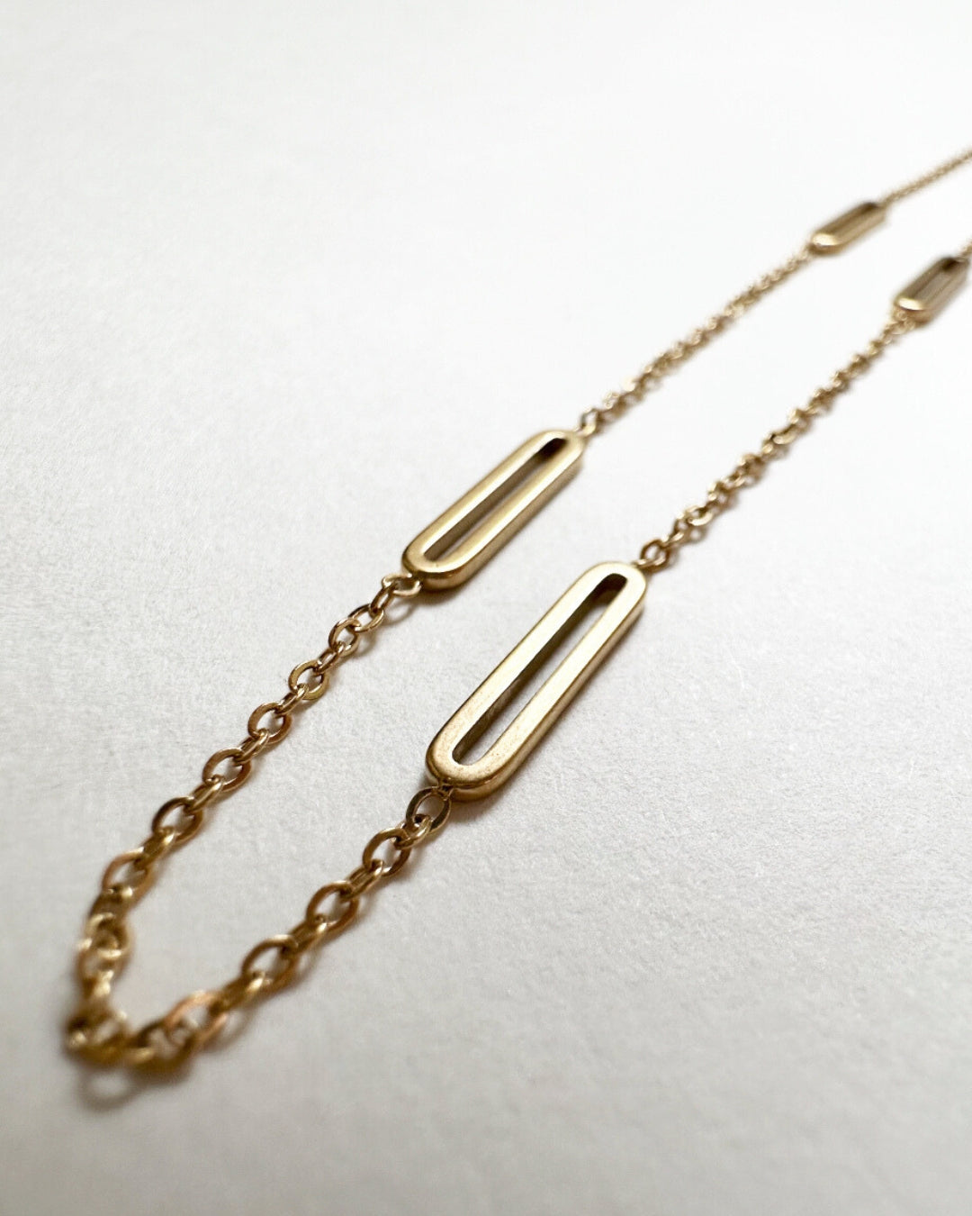 Close-up view of the paperclip chain links and trace chain on our Paloma Necklace.