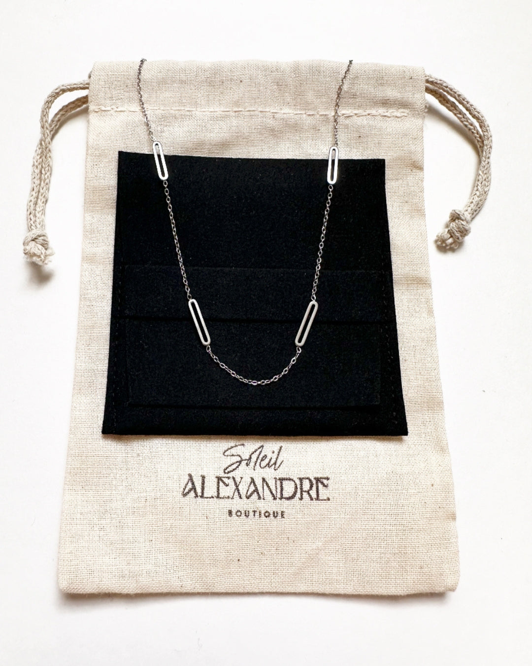 Silver Paloma Necklace shown styled on our drawstring jewelry bag.