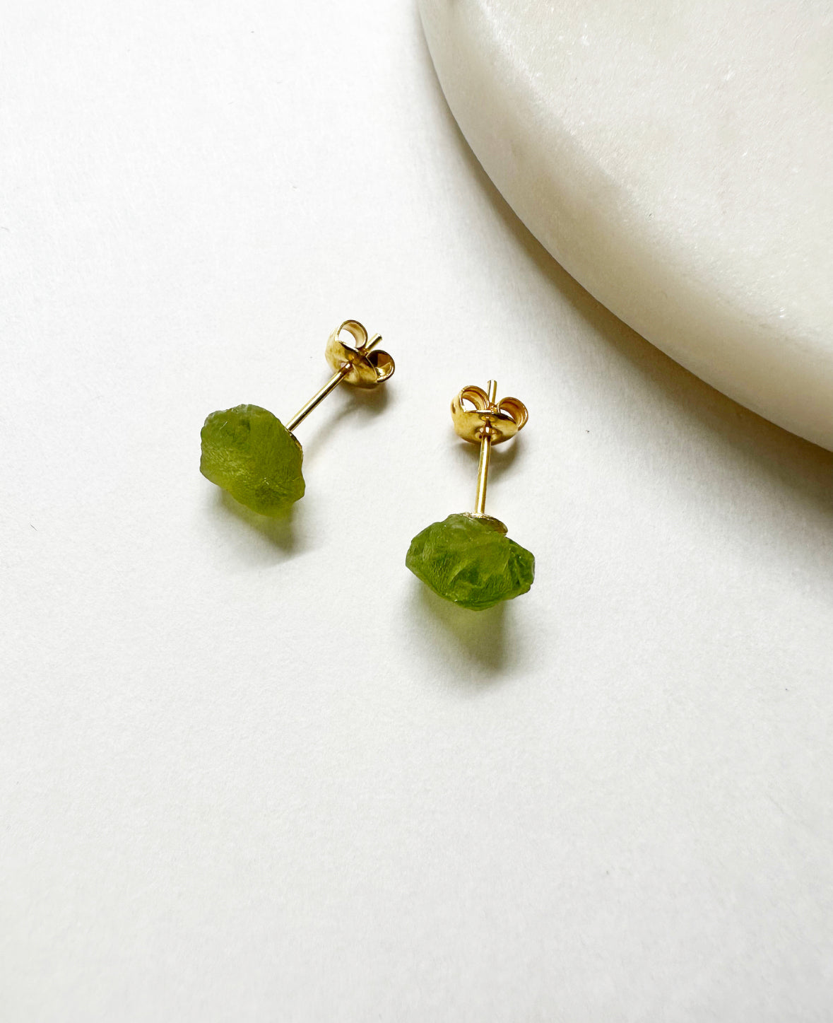 Raw peridot birthstone stud earrings with 14k gold post.