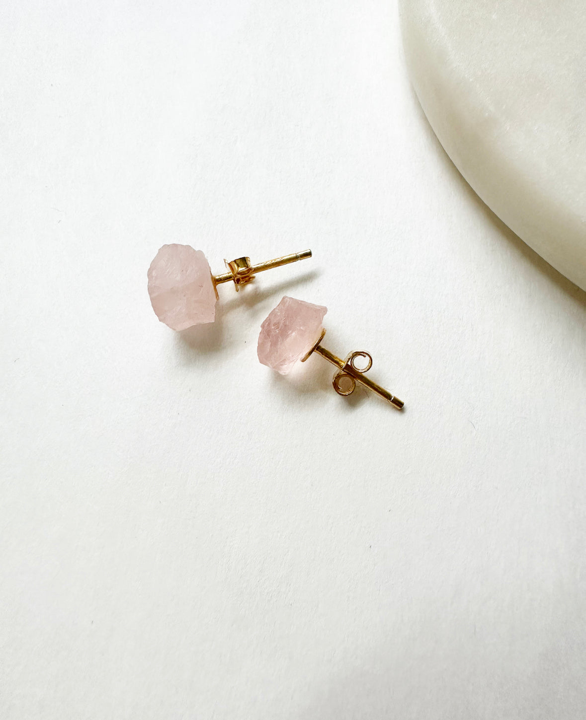 Raw rose quartz birthstone stud earrings with 14k gold post.