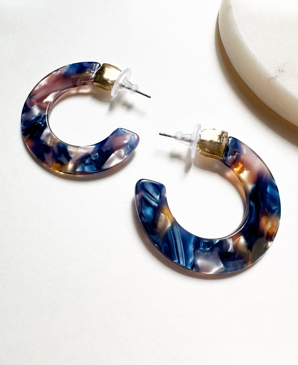 Full view of our Leilani Hoops in Oceanic Blue. Features dark blue, peach, pink, and white acrylic swirls with gold hardware.