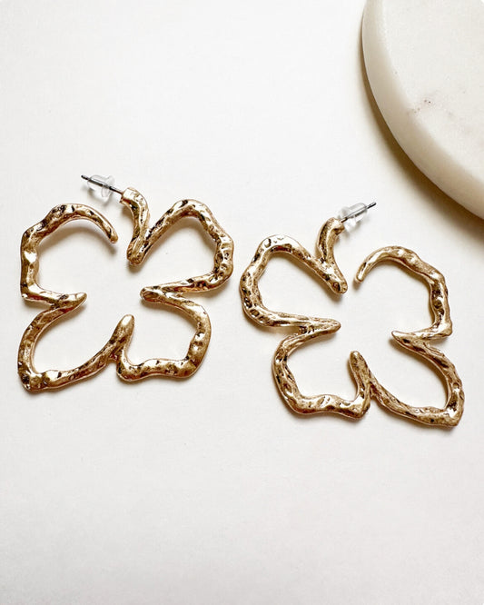 Our Xochitl Earrings featuring a unique, textured muted gold floral shape with push-back closure.