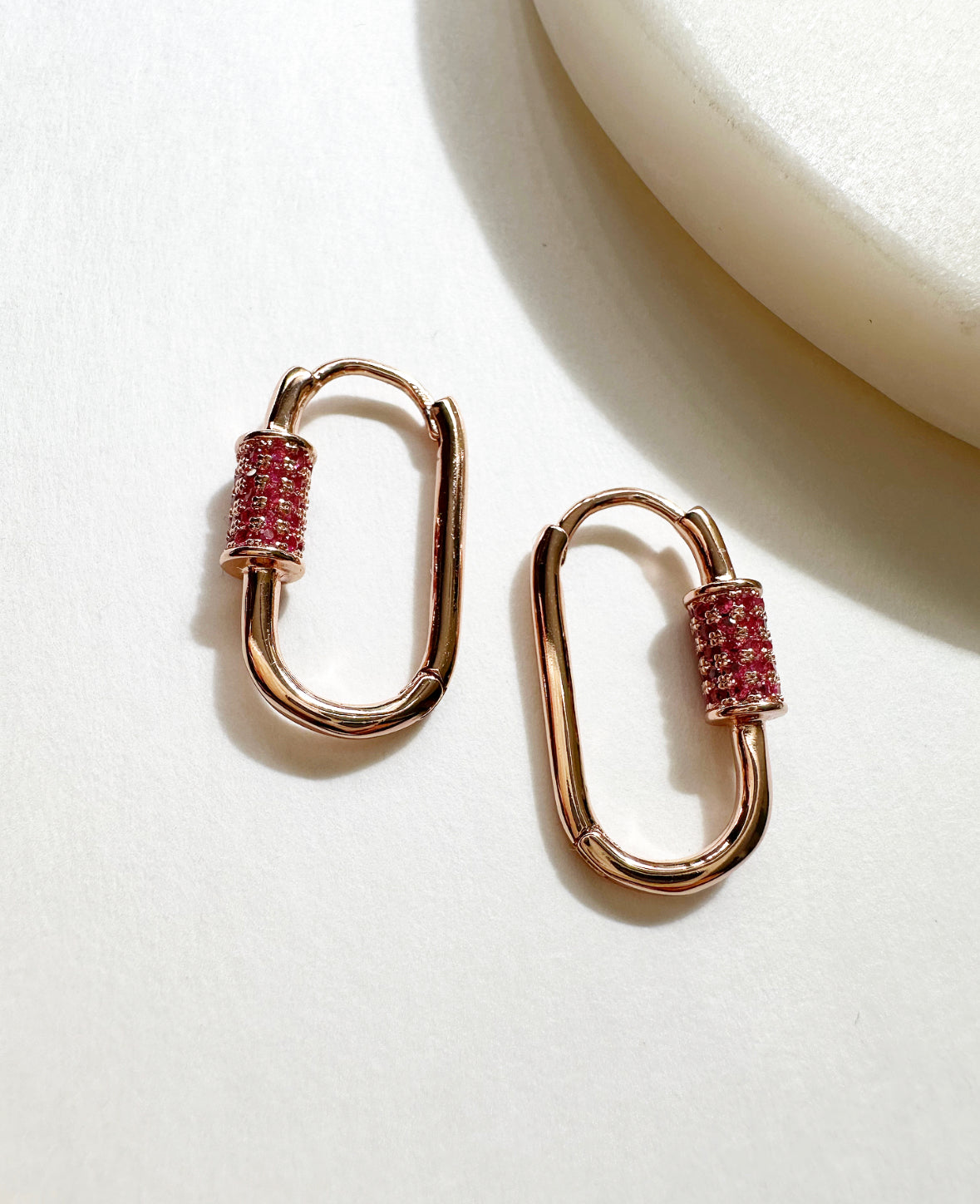 Rose gold carabiner-shaped Cherry Blossom Journey Earrings with pink pavé crystal detail.