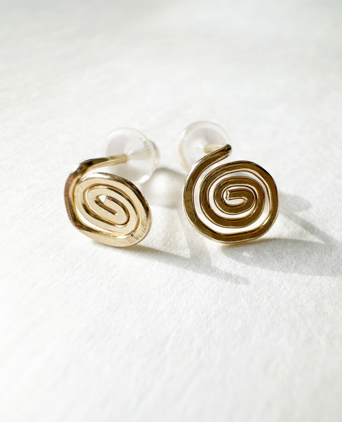 Close-up of 14k Gold Vortex Stud Earrings.