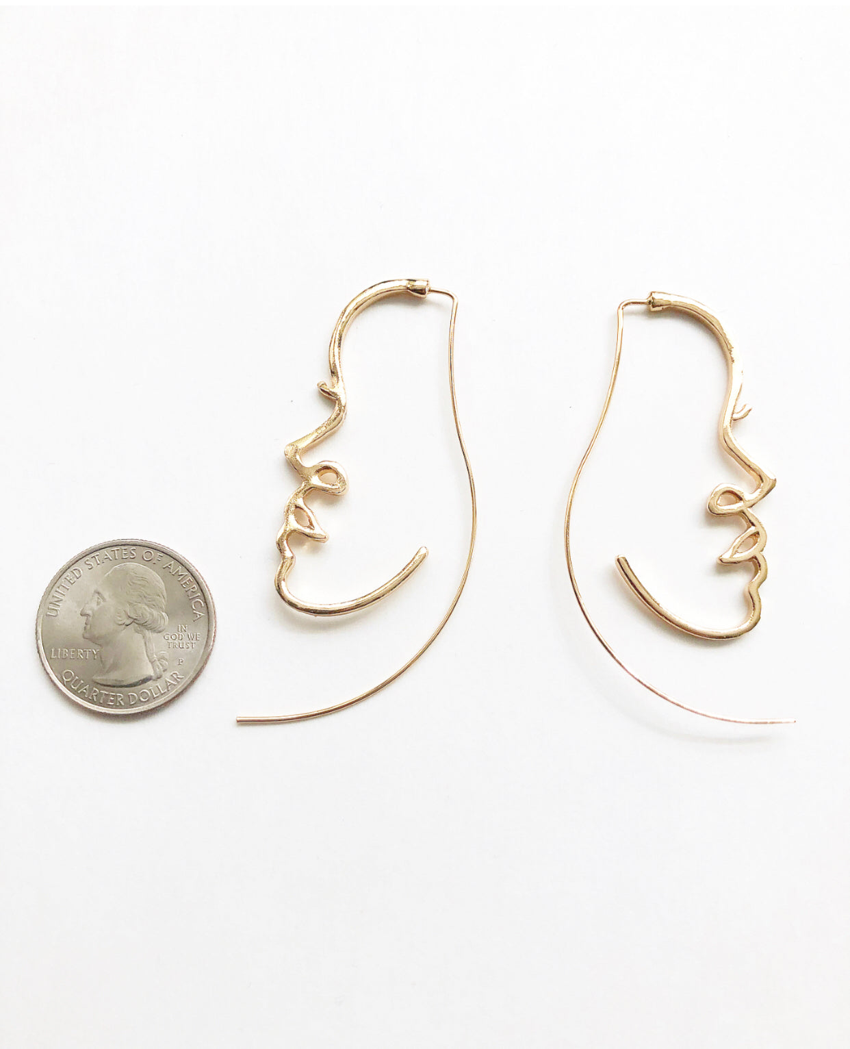 Portrait of a Lady Earrings next to a quarter for size comparison.