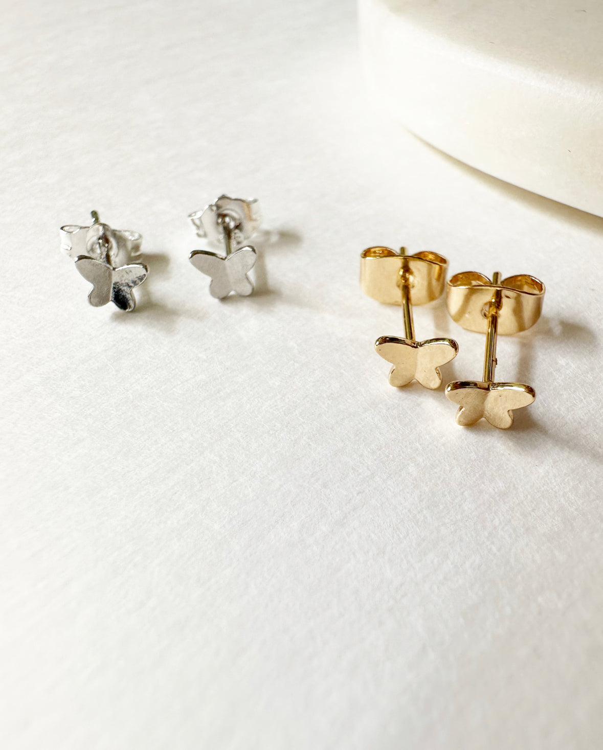 Gold and Silver small, butterfly-shaped Tiny Flutters Stud Earrings.